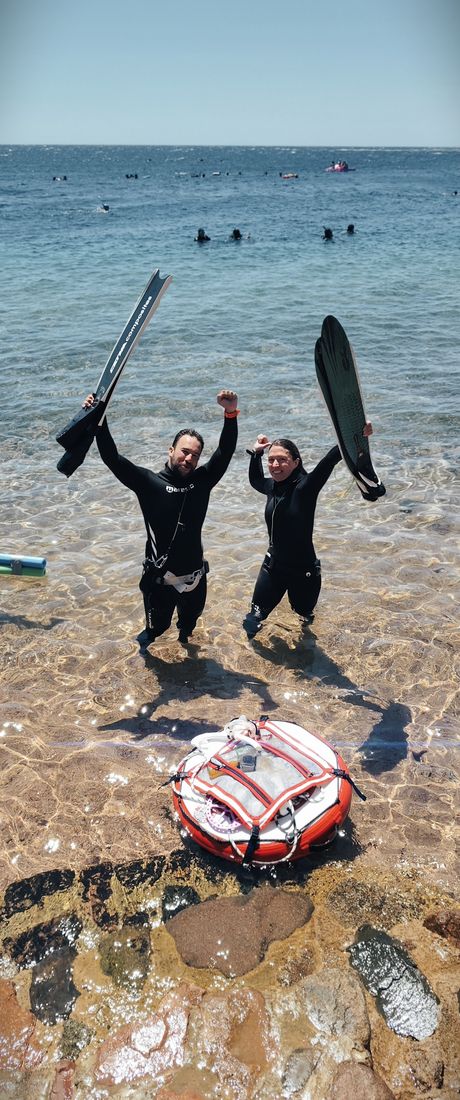A pair celebrating arms-up in the shallows