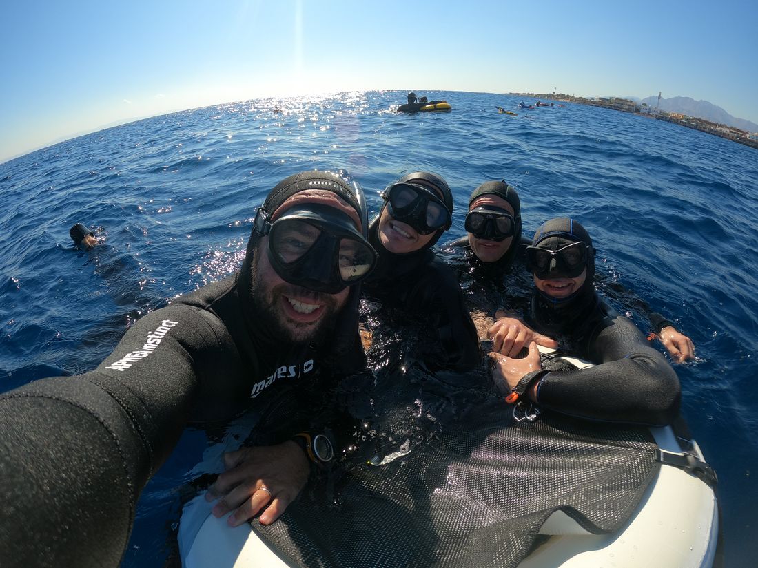 The group smiling on the boat after a dive