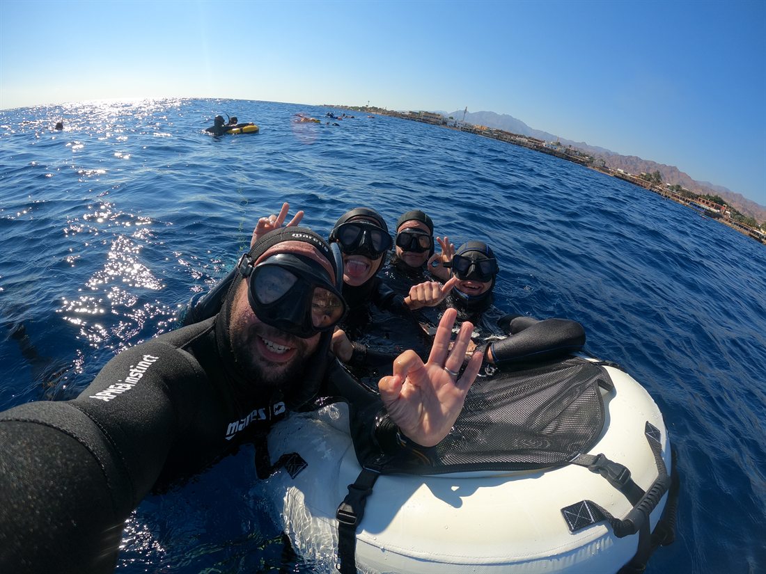 The whole crew smiling together on the buoy after an open-water session